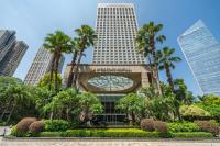 a building with a clock in front of palm trees at InterContinental Foshan by IHG - Free Shuttle Bus to Canton Fair in Foshan