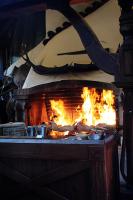 Una chimenea con fuego y ollas y sartenes. en Spa Hotel Rich, en Velingrad