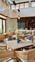 un ristorante con tavoli e sedie in una stanza di Alima ARQ Beach Resort a Brtania