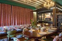 ein Esszimmer mit Tischen und Stühlen und einem Kronleuchter in der Unterkunft SIGMA Suites Hotel in Thessaloniki