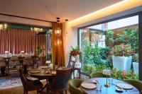 ein Restaurant mit Tischen und Stühlen und einem großen Fenster in der Unterkunft SIGMA Suites Hotel in Thessaloniki