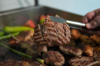 una persona che tiene un pezzo di carne con una spatola di Kent Room Hotel a Kapaklı