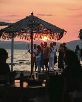 un gruppo di persone in piedi sotto un ombrellone sulla spiaggia di Victoria's Suites Corfu a Lefkimmi