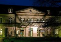 a building with a lit up front of it at night at Novotel Hildesheim in Hildesheim