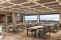 Un comedor con mesas y sillas y grandes ventanales. en Delta Hotels by Marriott Istanbul Karakoy, en Estambul