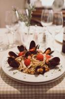 a plate of pasta with mussels and tomatoes on a table at C&C Residence Hotel in Bacău