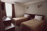 a hotel room with two beds and a window at C&C Residence Hotel in Bacău