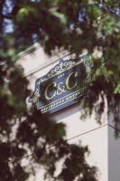 a sign on a building with trees in the foreground at C&C Residence Hotel in Bacău
