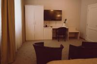 a room with a desk with a tv and a table with chairs at C&C Residence Hotel in Bacău