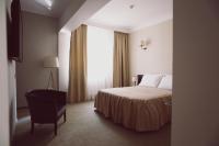 a bedroom with a bed and a chair and a window at C&C Residence Hotel in Bacău