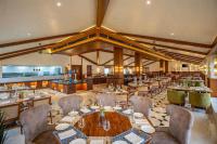 um restaurante com mesas, cadeiras e um bar em Radisson Resort Mount Abu em Monte Abu
