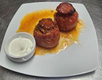 Un plato con dos pasteles y un bol de salsa. en Pensiunea Alex, en Cheia