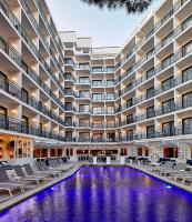 an apartment building with a swimming pool and chairs at Delamar 4*Sup-Adults only (18+) in Lloret de Mar