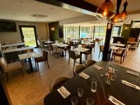 Hôtel Restaurant Le Brennus Logis Hotels في لانغون: غرفة طعام مع طاولات وكراسي ومطعم