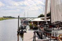 un groupe de bateaux amarrés à un quai dans l'eau dans l'établissement Tiny Boat House #4, à Garnwerd
