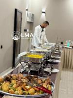 a chef standing in a kitchen preparing food at LMA Rum Luxury Camp in Wadi Rum