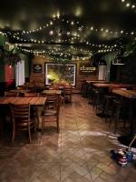 a restaurant with wooden tables and chairs and lights at Auberge-Bistro Rose et Basilic in Alma