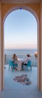 two women sitting at a table looking out at the ocean at Hotel Grotta Palazzese in Polignano a Mare