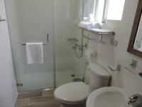 a white bathroom with a toilet and a shower at Happy Life B&amp;B in Donggang