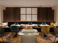 Mercure Le Mans Batignolles - Hotel & Spa في لو مان: غرفة طعام بها طاولات وكراسي وطاولة عليها كؤوس نبيذ