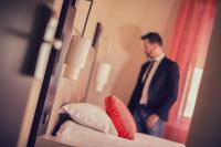 a man in a suit standing in front of a mirror at Best Western Plus Richelieu in Limoges