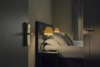 a bedroom with a bed and a table with a lamp at Best Western Plus Richelieu in Limoges