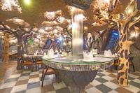 a dining room with a tree themed wall at Hotel Shady Oaks in Srinagar