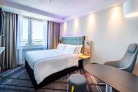 una habitación de hotel con una cama y un escritorio en Premier Inn Köln City Süd, en Colonia