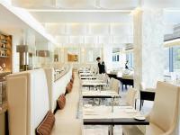 uma sala de jantar com mesas e cadeiras brancas em Fairmont Baku, Flame Towers em Baku