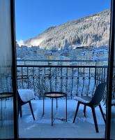 Un balcón con dos sillas y una mesa y una vista. en Residenz Boutique Suites, en Bad Gastein