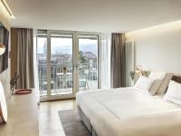 Un dormitorio con una gran cama blanca y un balcón. en Swissôtel Kursaal Bern, en Berna