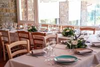 StradaにあるCasa di Palaiaのテーブルと椅子、グラス、花のあるダイニングルーム