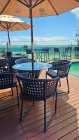 サンルイスにあるLitorânea Praia Hotelのテーブルと椅子、パラソル付きのデッキ
