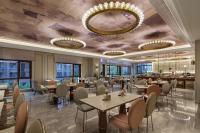 Un restaurante con mesas y sillas y un bar. en Mercure Xi'an Chanba, en Xi'an