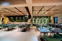 a dining room with tables and green chairs at Greyfield Hotel and Apartments in Benin City