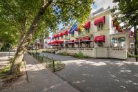 a building with red umbrellas on a city street at Bilderberg Grand Hotel Wientjes in Zwolle