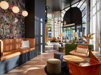 a lobby with chairs and tables in a building at Radisson Hotel Clermont-Ferrand in Clermont-Ferrand