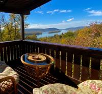 a balcony with a table and chairs and a view of a lake at Szegfű33 Vendégház in Zebegény