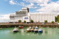Un grupo de barcos en el agua frente a un edificio. en The Grand Burstin Hotel, en Folkestone