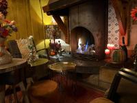 ein Wohnzimmer mit einem Kamin, einem Tisch und einem sidx sidx in der Unterkunft Hotel Boerderij Restaurant De Gloepe in Diffelen