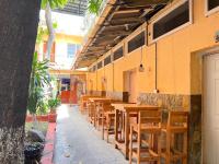 eine Reihe von Holztischen und -stühlen neben einem Gebäude in der Unterkunft Hotel Hernandez in Chiquimula