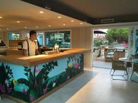 Un hombre de pie en un mostrador de un restaurante. en Masd Mediterraneo Hotel Apartamentos Spa, en Castelldefels