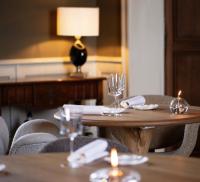 a wooden table with chairs and wine glasses on it at Le Petit Serrant - maison d'hôtes d'exception in Bouchemaine