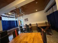 a dining room with wooden tables and chairs at New Hotel Rhino in Guwahati