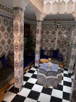 La paillade في Oulad Barrehil: غرفة معيشة مع طاولة وأرضية لوح خشب