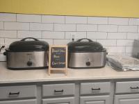 湖城湖城速8酒店的两个锅碗瓢盆放在柜台上，旁边立着一块牌子。