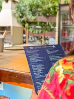 Uma pessoa está segurando um cardápio em uma mesa. em EstrelaMar Ferradura Restaurante & Spa em Búzios