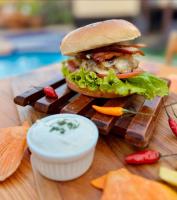 um sanduíche em uma bandeja de madeira com molho para mergulhar em EstrelaMar Ferradura Restaurante & Spa em Búzios