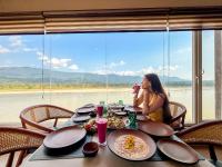 a woman taking a picture of a table with food at The Neeraj Ganga Rajmahal Wellness Dream in Rishīkesh