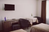 a hotel room with a table and a tv on the wall at C&C Residence Hotel in Bacău